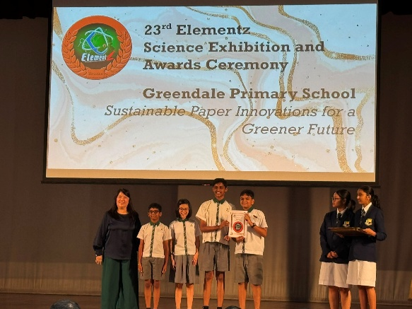 Students receiving an award on stage at a science exhibition and awards ceremony.